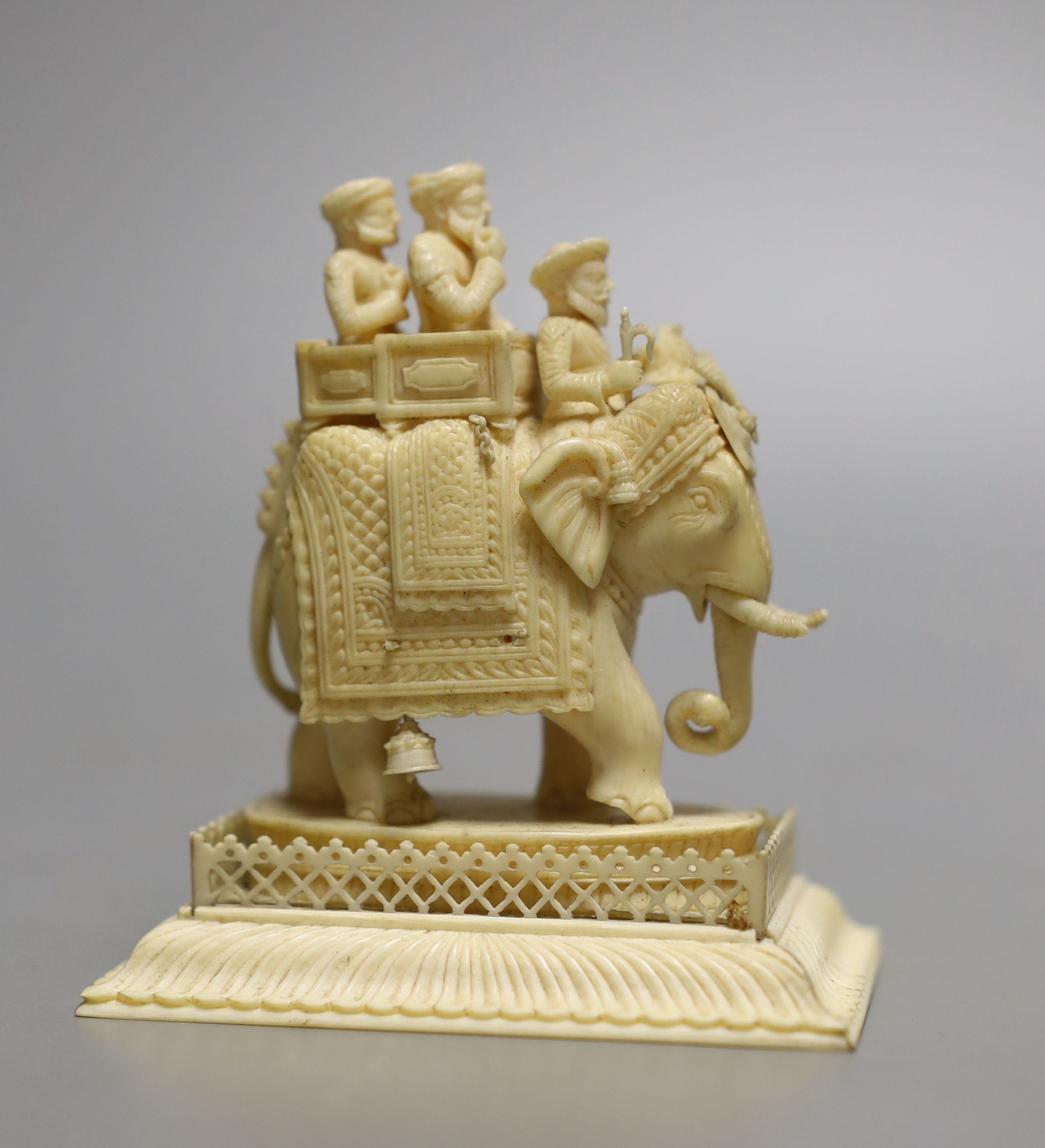 A 19th century Indian carved ivory of figures on a caparisoned elephant, 8.5cm tall, and two other small ivory carvings